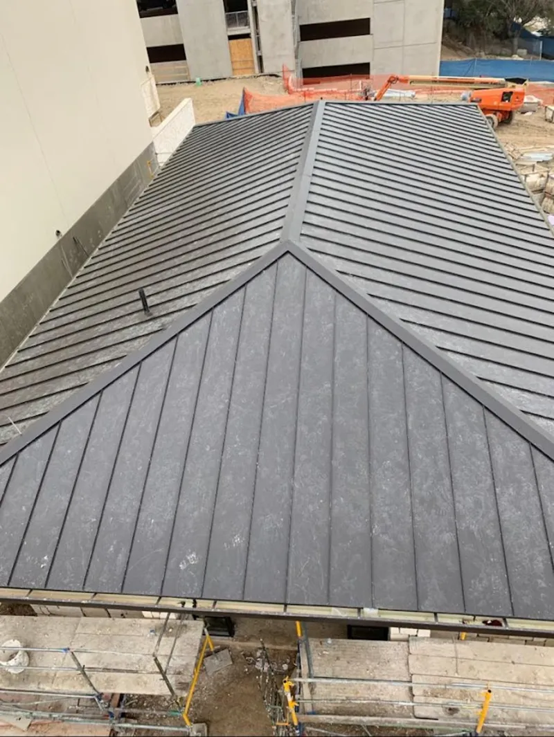 Commercial metal roof construction with crane equipment in Romeoville